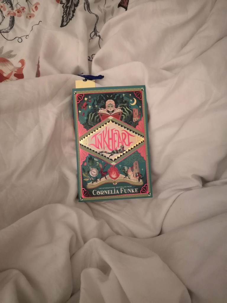 A picture of Inkheart by Cornelia Funke on a bed